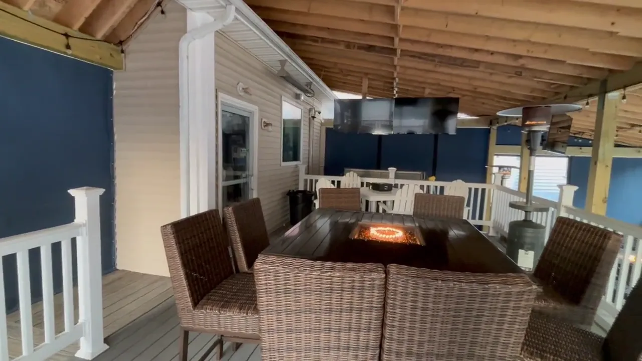 Covered patio at The Bar at the Patch with fire table and wicker seating